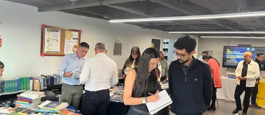 Docentes y proveedores en feria, revisando libros